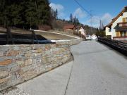 Auf der linken Seite befindet sich die errichtete Steinmauer - führt einer Straße entlang.