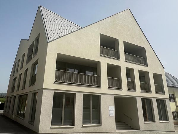 Außenansicht einer Wohn- und Geschäftsanlage - ein Haus mit mehreren Giebeln und vielen Fenstern.